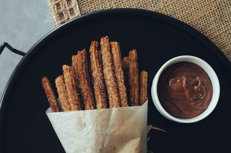 Churros with chocolate dipping sauce — crispy sweet dessert